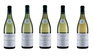 Kiev, Ukraine - March 10, 2020: Bottles of Chablis dry white wine, produced by the French vinery brand Domaine William Fevre, isolated on white background.