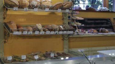 Kadın satıcı pastanede tezgahın üzerine ellerini koyar