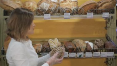 Woman puts black bread on the rack