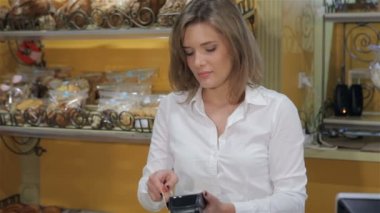 Woman processing credit card through the payment terminal