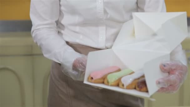 Woman shows the box with brewing cakes — Αρχείο Βίντεο