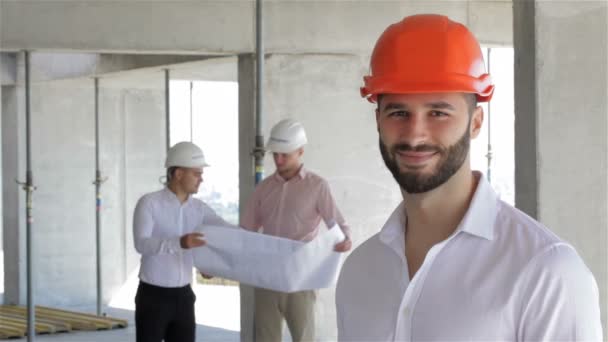 Ingeniero de construcción posa en el edificio en construcción — Vídeo de stock