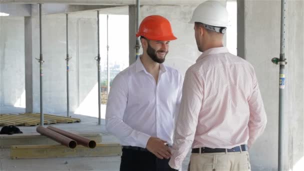 L'architecte et le constructeur serrent la main au bâtiment en construction — Video