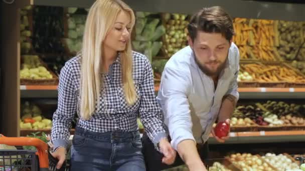 Мужчина берет три помидора из подноса в супермаркете — стоковое видео
