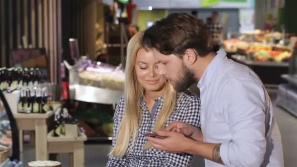 Paar Bereken de prijs van gekochte producten in de supermarkt — Stockvideo