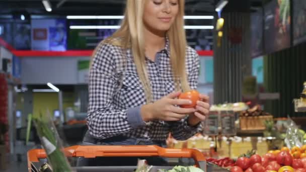 Mulher cheira o tomate no supermercado — Vídeo de Stock