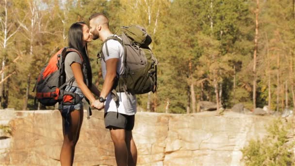 Fiatal pár túrázók csókok, közel a szikla — Stock videók