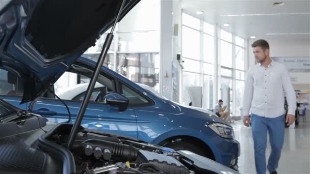 L'homme regarde le compartiment moteur de la voiture chez le concessionnaire — Video