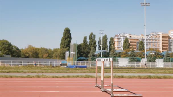 Due velocisti saltano oltre gli ostacoli allo stadio — Video Stock