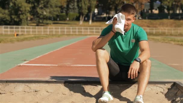 Atleta masculino limpa o rosto com a toalha — Vídeo de Stock