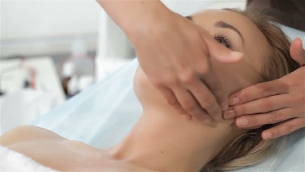 Masseur massages womans kin — Stockvideo