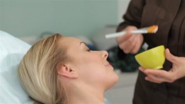 Güzellik uzmanı istemcileri yüz maskesi uygular