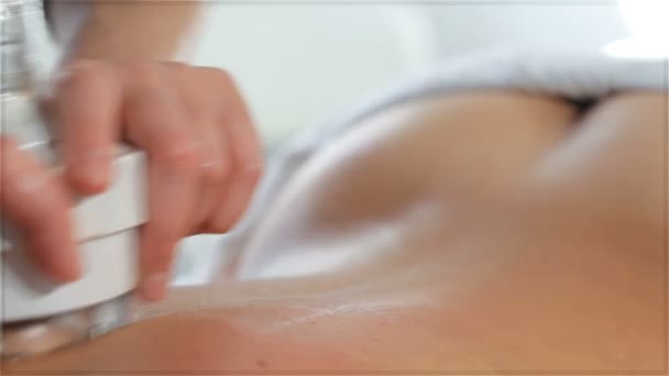 Las manos femeninas mueven el masajeador de la máquina de masaje a lo largo de la columna vertebral clientes — Vídeo de stock