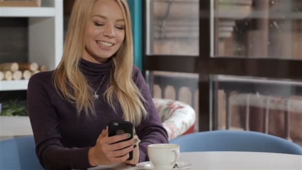 Messages de femme près de son téléphone portable au café — Video