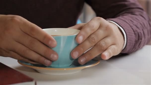 Male hands takes the cup with coffee from the saucer — ストック動画