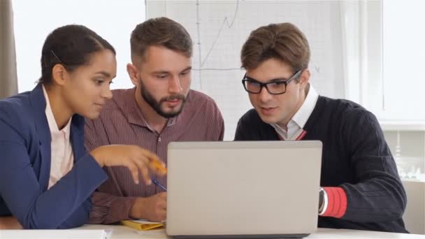 Creatieve team van twee mannen en een vrouw zitten op kantoor — Stockvideo