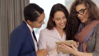 Üç kadın ofiste tablet bakarak
