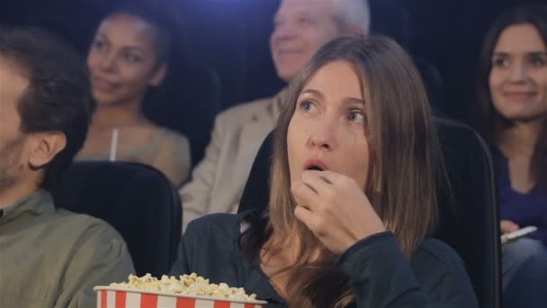 Woman eats popcorn at the movie theater — Stock Video