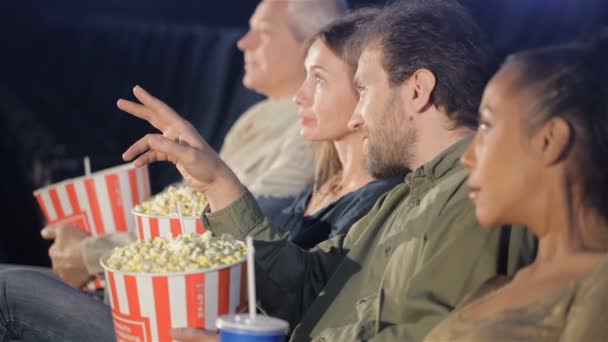 Люди держат ведра с попкорном в руках в кинотеатре — стоковое видео