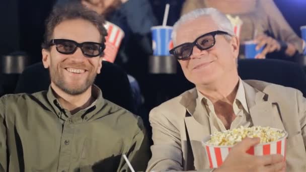 Двое мужчин смотрят 3D фильм в кинотеатре — стоковое видео
