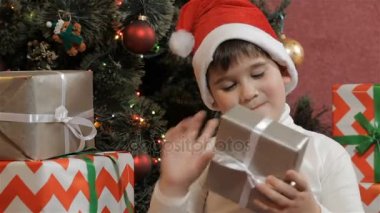 Küçük çocuk Noel hediye kutusu sallıyor