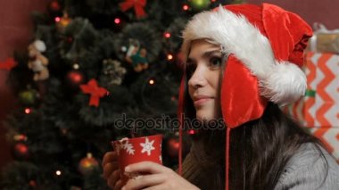 Biraz içecek içme santas şapkalı kadın