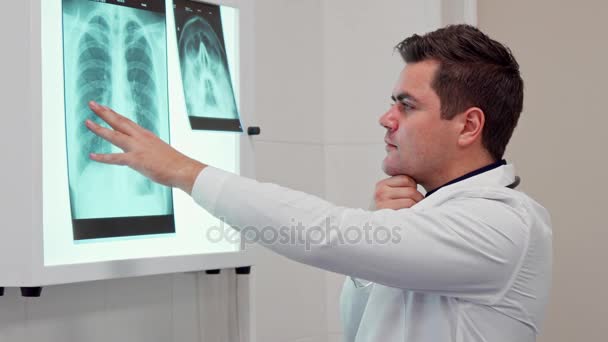 El médico masculino sostiene su mano sobre la imagen de rayos X — Vídeo de stock