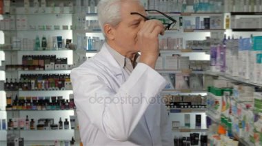 Erkek eczacısı eczanede gözlük takar