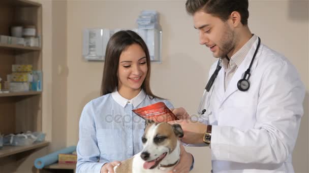 Hombre veterinario le dice al dueño del perro femenino sobre el tratamiento para su perro — Vídeos de Stock