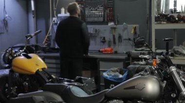 Erkek motorcu motosiklet üzerinde bir şey İngiliz anahtarı tarafından unscrews
