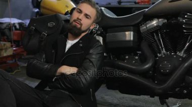 Erkek motorcu motosiklet yakın katta oturur