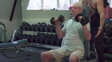 Eğitmen ellerini üst düzey istemci dirsek üzerinde tutar.