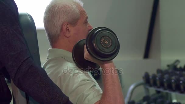 Trainer helps senior client during the training — Stock Video