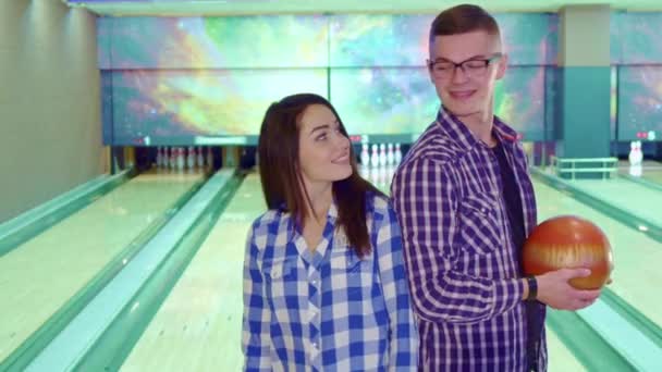 Boy and girl look at each other at the bowling — Stock Video