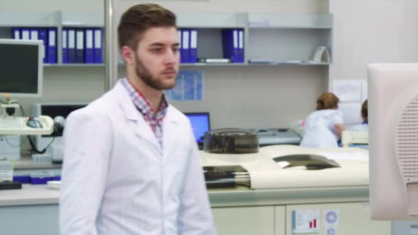 Man komt naar de monitor in het laboratorium — Stockvideo