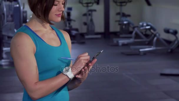 Mujer fitness posa en el gimnasio — Vídeo de stock