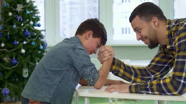 Vader en zoon armwrestle op tafel — Stockvideo
