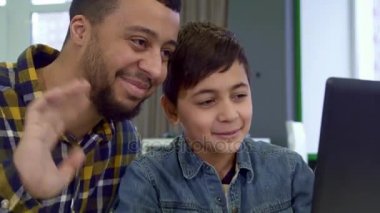 Baba ve oğul dizüstü bilgisayar ekranında bakın