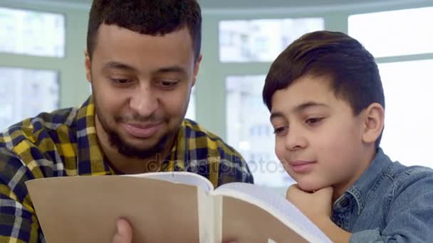 Padre e hijo mirando Draingn álbum — Vídeo de stock