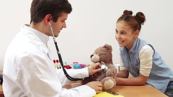 Uma menina levou seu ursinho de pelúcia para uma consulta médica . — Vídeo de Stock