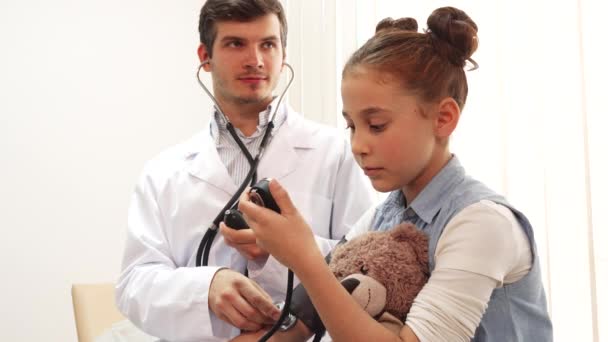 Опытный врач измеряет пациентам артериальное давление — стоковое видео