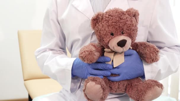 Profesyonel doktor bir oyuncak ayı tutar ve başparmak çıkar ortaya — Stok video