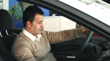 Dikkatli bir adam araba ve salon içinde düğmeleri direksiyon simidi üzerinde