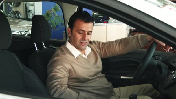 O homem satisfeito senta-se no carro e goza da qualidade — Vídeo de Stock
