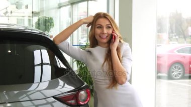 Araba Bayilik salon de onun akıllı telefon kullanan mutlu güzel kadın