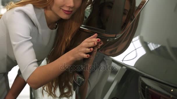 Recolhido de perto de uma mulher verificando pintura de carro em um novo automóvel na concessionária — Vídeo de Stock