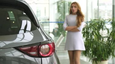 Güzel kadın yeni bir araba galerisinde seçerken düşünmek