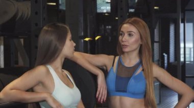 Spor stüdyosu kameraya gülümseyen iki güzel fitness kadınlar