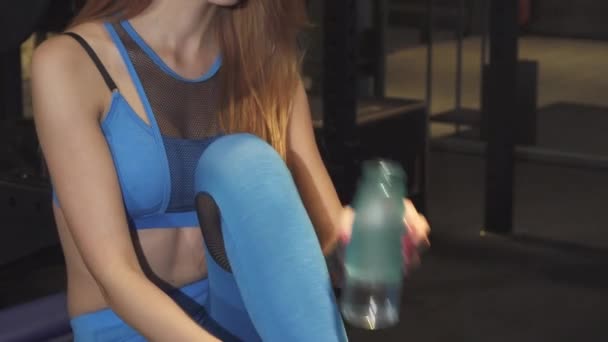 Mooie gelukkig fitness vrouw die lacht drinkwater na gym training — Stockvideo