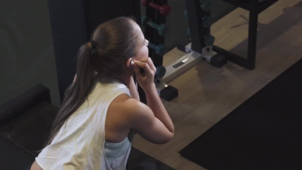 Vue de dessus prise d'une magnifique sportive gaie souriant à la caméra à la salle de gym — Video